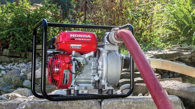 Plan étendu de la pompe de transfert reposant sur des pierres, le tuyau branché.