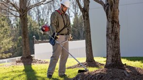 Une personne utilise un taille-bordures Honda à l’extérieur.  
