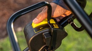 Close up of a person's hand pushing the blade stop system switch.
